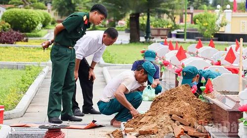 Phó Chủ tịch Ủy ban nhân dân phường Điện Bàn Bắc Phan Quang Quốc Huy (áo trắng) giám sát việc lấy mẫu hài cốt liệt sĩ tại Nghĩa trang liệt sĩ thị xã Điện Bàn (cũ).