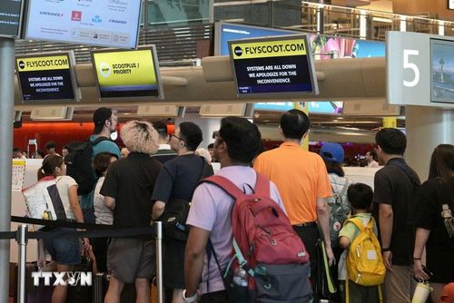 Hành khách xếp hàng tại quầy làm thủ tục ở sân bay Changi, Singapore. Ảnh: THX/TTXVN