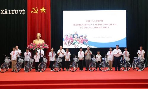 Các đại biểu trao học bổng và xe đạp cho học sinh có hoàn cảnh khó khăn.