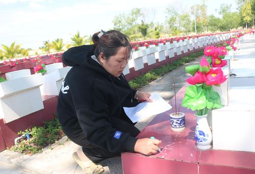 Chị Lan đánh số những phần mộ chưa xác định thông tin cho các lực lượng lấy mẫu, số hóa thông tin hài cốt liệt sĩ thực hiện nhiệm vụ