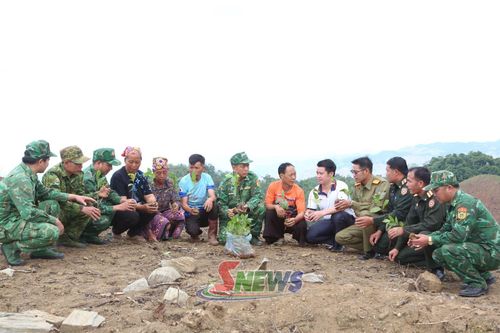 Cán bộ Đồn Biên phòng Chiềng Tương hướng dẫn nhân dân bản Móng Nặm (nước CHDCND Lào) kỹ thuật chăm sóc cây cà phê.