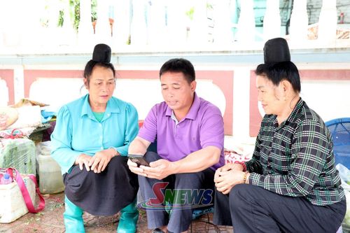Tổ công nghệ số cộng đồng hướng dẫn tiểu thương chợ Chiềng Mung cài đặt mã QR thanh toán.