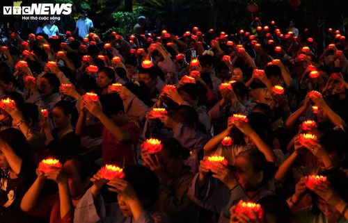 Hàng nghìn phật tử dâng những đóa hoa sen đỏ thắm trên đầu dịp lễ Vu Lan. (Ảnh: Mạnh Hiếu)