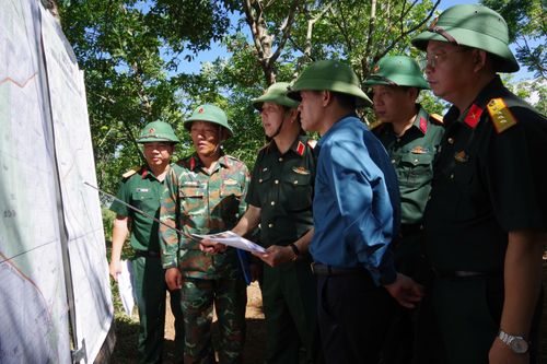 Nghiên cứu, khảo sát trên bản đồ để thông qua các phương án khảo sát tìm kiếm, quy tập hài cốt liệt sĩ tại căn cứ Cồn Tiên. (Ảnh: Hoàng Cuối)