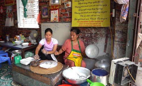 Bà Hoàng Thị Lan truyền dạy cho con gái nghề làm bánh cuốn. Ảnh: Nguyễn Công