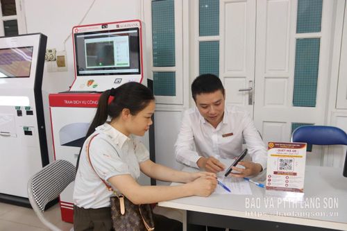 Cán bộ ngân hàng tư vấn cho người dân về các sản phẩm dịch vụ ngân hàng điện tử