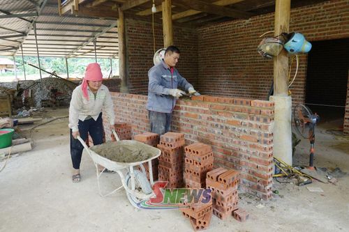 Người dân bản Nam Nghè dựng lại nhà cửa sau khi công trình khắc phục ngập úng hoàn thành.