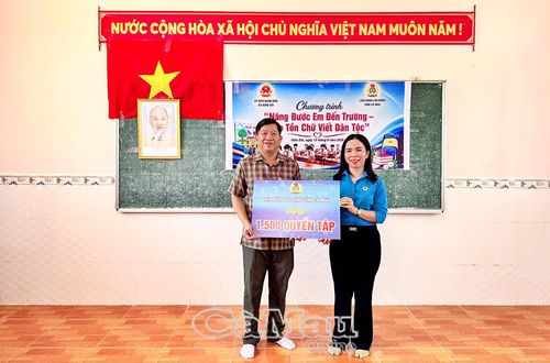 Bà Ngô Diễm Phúc, Phó Chủ tịch Thường trực Liên đoàn Lao động tỉnh Cà Mau, trao bảng tượng trưng tặng 1.500 quyển tập đến Chủ tịch UBND xã Đầm Dơi Nguyễn Trí Tài.