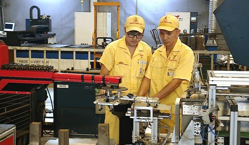 Anh Nguyễn Văn Thịnh (phải) cùng đồng nghiệp nghiên cứu thiết bị tự động hóa. Ảnh: Nguyễn Công