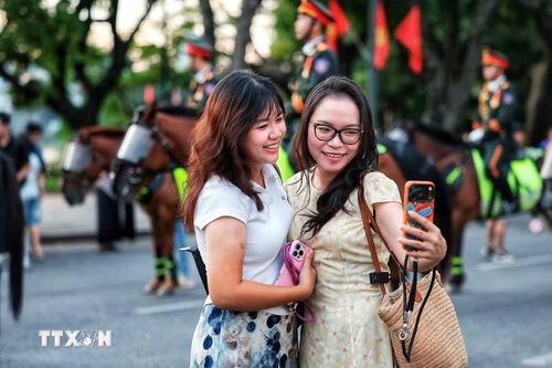 Người dân vui vẻ chụp ảnh lưu niệm bên cạnh đoàn kỵ binh. (Ảnh: Phạm Tuấn Anh/TTXVN)