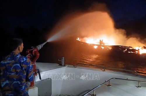 Các lực lượng nỗ lực dập lửa trên 3 tàu cá tại cảng Hồng Anh, xã Rạng Đông (Ninh Bình) trong đêm. Ảnh: TTXVN phát