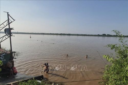 Chỉ vài chục mét sau biển cảnh báo nguy hiểm, nhiều người vẫn vô tư tắm ở bãi tắm tự phát bên bờ sông Hồng, đoạn qua phường Phú Thượng. Ảnh: Nguyễn Thắng/TTXVN