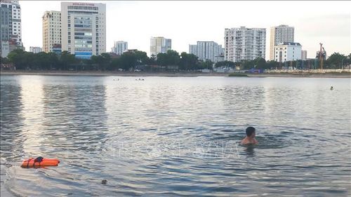Người dân vô tư tắm ở Hồ Linh Đàm mặc dù đã có biển báo cấm tắm. Ảnh: Nguyễn Thắng/TTXVN