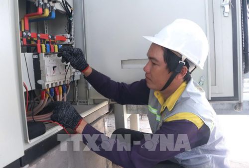 Kỹ thuật viên của doanh nghiệp kiểm tra hệ thống điện năng lượng mặt trời phục vụ sản xuất. Ảnh: Tuấn Phi - TTXVN