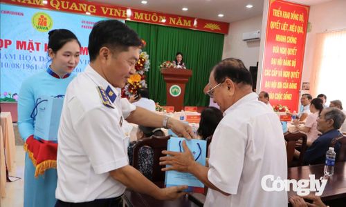 Đại tá Dương Xuân Dũng - Phó Chủ nhiệm Chính trị, Bộ Tư lệnh Vùng Cảnh sát biển 4 trao quà cho các nạn nhân chất độc da cam