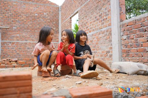 Niềm vui của trẻ nhỏ bên căn nhà mới đang được xây dựng cho gia đình chị Hồ Thị Tre. Ảnh: TRÂM ANH
