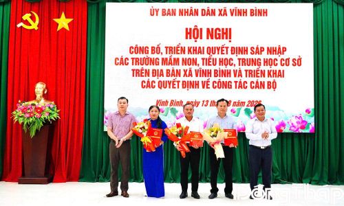 Đồng chí Trần Quốc Bình, Bí thư Đảng ủy, Chủ tịch HĐND xã (bìa trái) và đồng chí Nguyễn Trung Tín, Phó Bí thư Đảng ủy, Chủ tịch UBND xã (bìa phải) trao các Quyết định tại hội nghị.