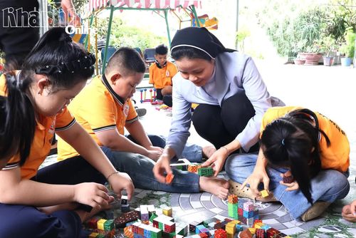 Các nữ tu hướng dẫn trẻ khuyết tật học chữ, xếp hình, rèn luyện kỹ năng.