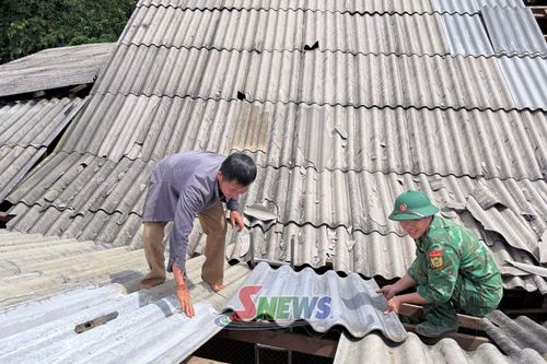 Cán bộ, chiến sĩ Đồn Biên phòng Mường Lạn hỗ trợ nhân dân bản Pá Cạch lợp lại mái nhà.