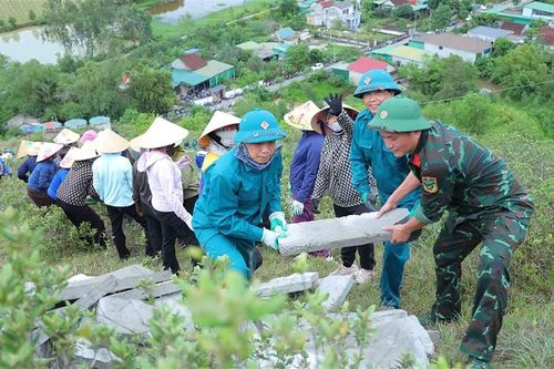 Cán bộ, chiến sĩ và người dân xã Lam Thành chung tay thay áo mới cho công trình lịch sử. (Ảnh: Hà Huệ)