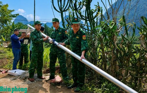 Cán bộ, chiến sĩ Đồn Biên phòng Đức Long, Bộ đội Biên phòng Cao Bằng và nhân dân địa phương lắp đặt đèn năng lượng mặt trời chiếu sáng tại khu dân cư biên giới. Ảnh: Quốc Sơn