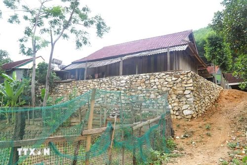 Tình trạng sạt lở ven suối diễn biến phức tạp nên nhiều hộ dân phải gia cố bờ đất quanh nhà bằng những bờ kè cao để hạn chế nguy cơ sạt lở trong mùa mưa. (Ảnh: Xuân Tiến/TTXVN)