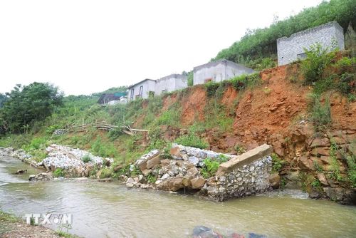 Bờ kè dài hàng chục mét bị lũ ống, lũ quét gây xói lở, đổ sập khiến nhiều ngôi nhà sinh sống phía trên bị đe dọa nghiêm trọng. (Ảnh: Xuân Tiến/TTXVN)