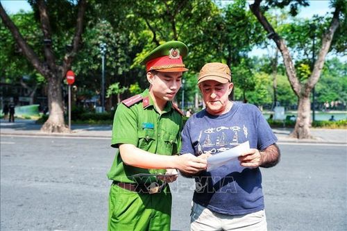 Cán bộ Công an giới thiệu cho một du khách nước ngoài tìm hiểu thông tin về Kiosk “Trạm Cảnh sát thông minh”, góp phần giúp người nước ngoài tiếp cận thuận tiện hơn với các dịch vụ hỗ trợ của lực lượng Công an. Ảnh: Phạm Tuấn Anh/TTXVN