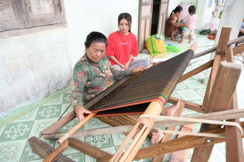 Mỗi chiều bà Thuận lại ngồi bên khung cửi dệt nên những tấm vải có họa tiết theo yêu cầu