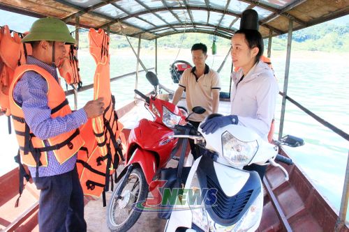 Chủ thuyền trang bị áo phao cho khách khi qua sông.