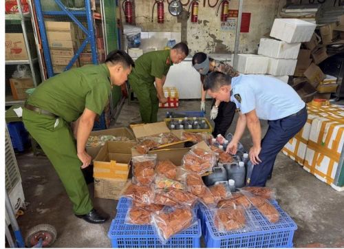 Lực lượng chức năng đang kiểm tra hàng hoá vi phạm, tại cơ sở kinh doanh. Ảnh: Công an TP Hà Nội.