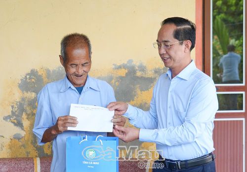 Phó Bí thư Tỉnh uỷ, Chủ tịch Uỷ ban MTTQ Việt Nam tỉnh Cà Mau Hồ Thanh Thuỷ trao tặng phần quà tri ân đến thân nhân liệt sĩ Đinh Văn Ngữ.