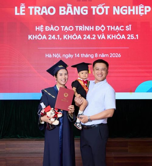 Ông xã Phạm Phú Đạt bế con trai, bé Pi, đến chúc mừng cô nhận bằng Thạc sĩ. Em bé Pi sắp tròn một tuổi được mẹ chuẩn bị cho một bộ đồ đồng điệu với trang phục tốt nghiệp của cô.
