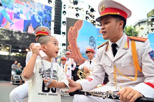 Em bé vui vẻ trò chuyện với nhạc công Đội Nghi lễ - CATP Hà Nội
