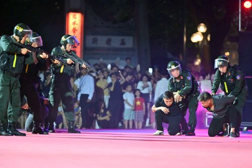 Cao trào bắt giữ: súng chĩa thẳng, các đối tượng bị khống chế quỳ giữa sân khấu, ánh đèn đỏ hồng nhuốm cả một góc phố đi bộ. Pha hành động này được chính các chiến sĩ Cảnh sát cơ động đặc nhiệm CATP Hà Nội thực hiện
