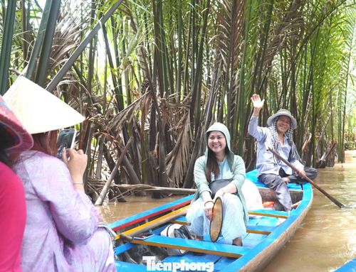  Vào buổi trưa, chỉ cần nhìn xuống con rạch, dễ dàng bắt gặp các "nàng thơ" rực rỡ vói áo bà ba, khăn rằn, đội nón lá mải mê lưu lại những khoảnh khắc đẹp dưới tán dừa nước. 