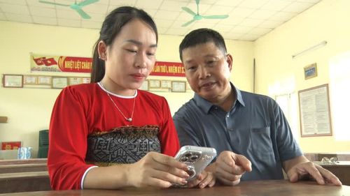 Ông Nhiệt hướng dẫn đảng viên cài đặt ứng dụng Sổ tay Đảng viên điện tử.