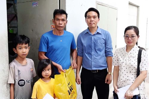 Ông Nguyễn Công Hậu (thứ 2 từ phải qua), Chủ cửa hàng điện máy Hậu trao quà cho học sinh tại khu nhà trọ. Ảnh: Viết Cường