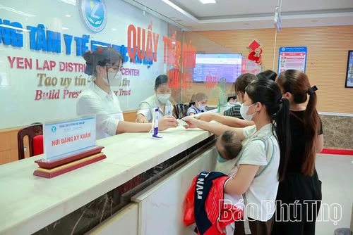 Cán bộ y tế hướng dẫn người dân làm thủ tục đăng ký khám bệnh tại Trung tâm Y tế khu vực Yên Lập.