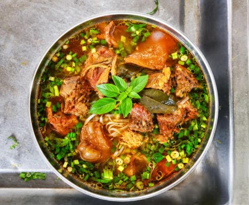 Phở bò sốt vang với thịt bò hầm, ăn cùng với rau thơm để tăng hương vị.