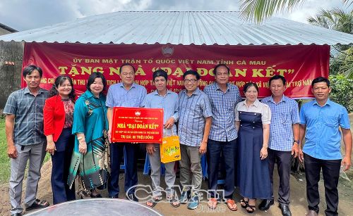 Ông Nguyễn Văn Đình Em (thứ năm từ trái sang) xúc động đón nhận kinh phí hỗ trợ xây dựng nhà Đại đoàn kết.