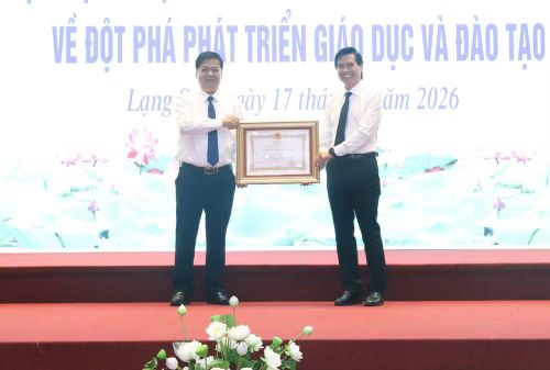 Phó Giám đốc Sở Giáo dục và Đào tạo tỉnh Lạng Sơn Đặng Hồng Cường (bên trái) nhận Huân chương Lao động hạng Ba tại hội nghị. (Ảnh: AT)