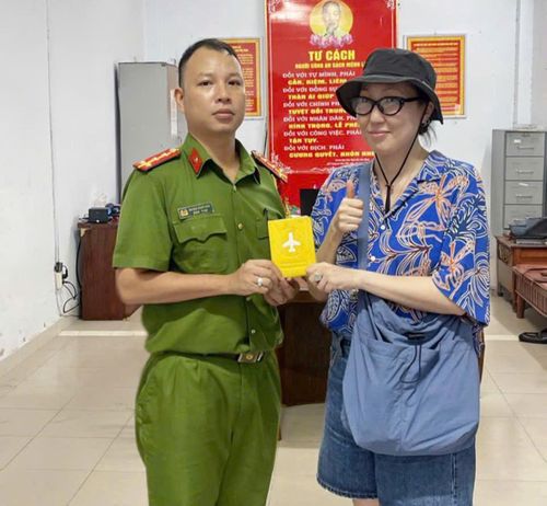 Cán bộ Công an phường An Hải trao trả hộ chiếu cho nữ du khách Nga.