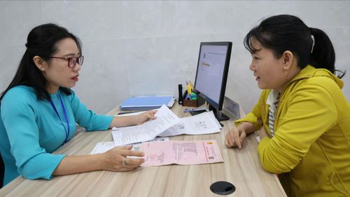 Chuyên viên pháp lý tại Văn phòng công chứng Nguyễn Thị Hồng Nhung (phường Dĩ An, TPHCM) hỗ trợ giải quyết thủ tục hành chính cho người dân (ẢNH: LÊ THOA)