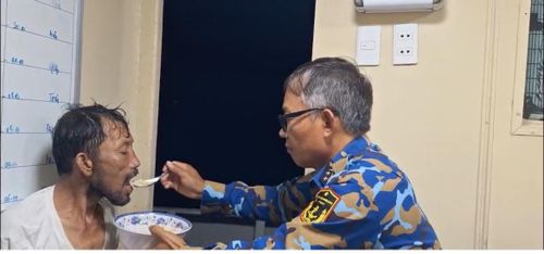  Ngư dân Trương Văn Trung được chiến sĩ tàu 743 hỗ trợ ăn uống. Ảnh: QUỐC HÙNG 