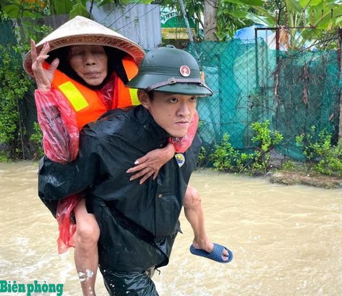 Cán bộ Bộ đội Biên phòng tỉnh Khánh Hòa giúp đỡ người già di chuyển đến nơi an toàn trong trận lũ lớn năm 2025. Ảnh: Lệ Giang