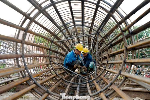 Công nhân, máy móc hoạt động liên tục trên công trường. Các đơn vị đang tranh thủ từng khoảng thời tiết thuận lợi trước khi điều kiện thi công trên sông chịu ảnh hưởng nhiều hơn bởi mùa mưa lũ.