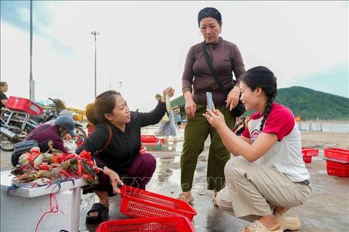 Khách mua hải sản tại cảng cá Cửa Nhượng.