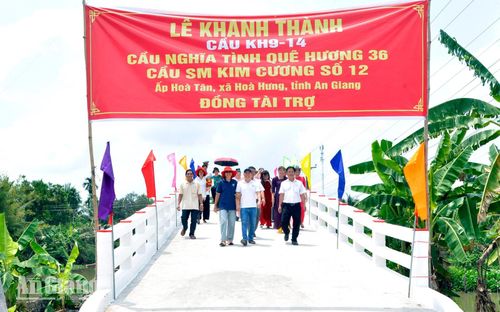Đại biểu và người dân phấn khởi đi trên cầu KH9-14 mới được khánh thành tại ấp Hòa Tân, xã Hòa Hưng.