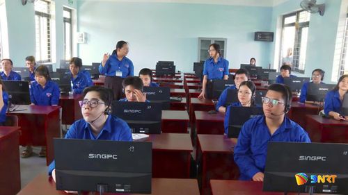 Cô giáo trẻ Lê Thị Hồng Vy Trường THPT Liên Chiểu (đeo thẻ) đang hướng dẫn, dạy kèm tiếng Anh cho học sinh có hoàn cảnh khó khăn trong lớp học mùa hè. Ảnh: T.HƯƠNG